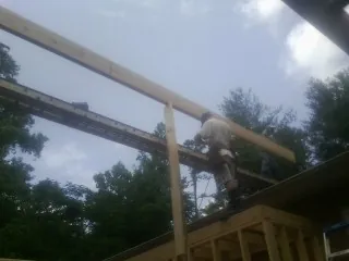 Carpenter setting a ridge beam over a new addition frame — Ice Dam Removal by Roofing Brothers in Indian Hills