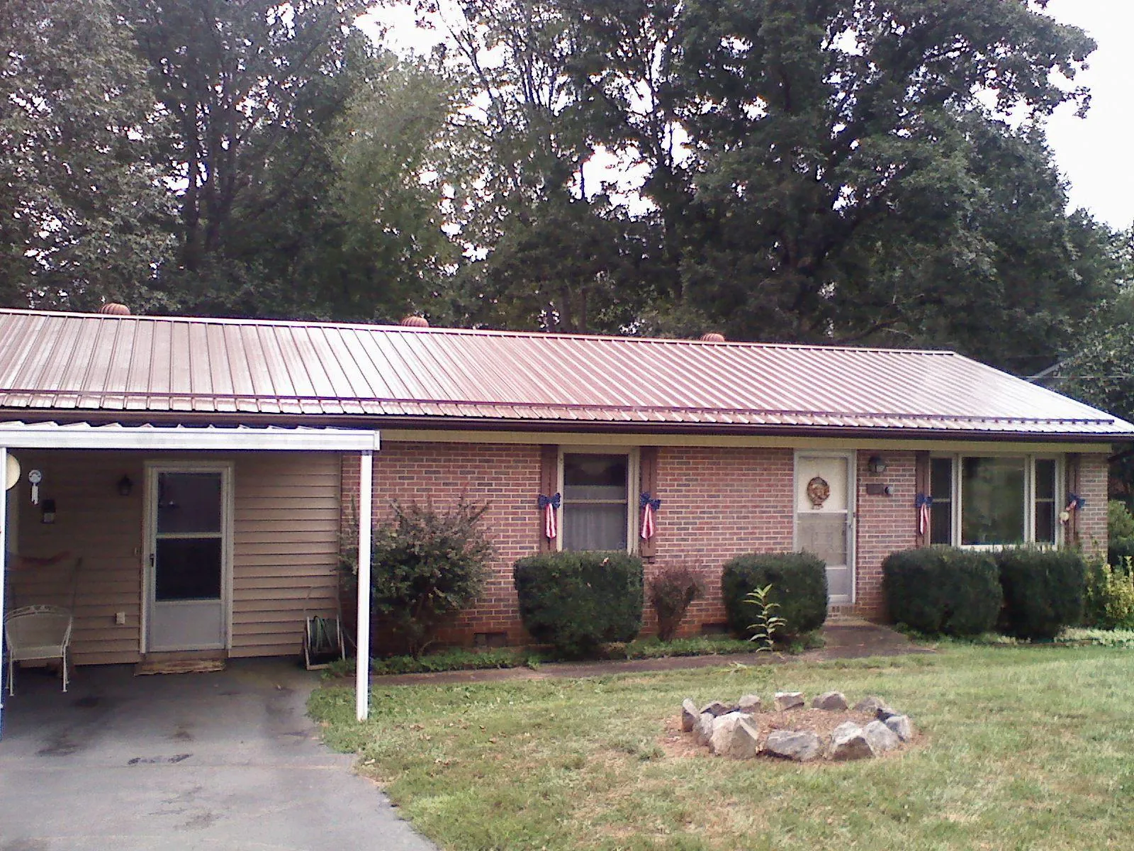 Bronze metal roof and carport on a brick ranch home — Roof Repair work by our crew in Indian Hills